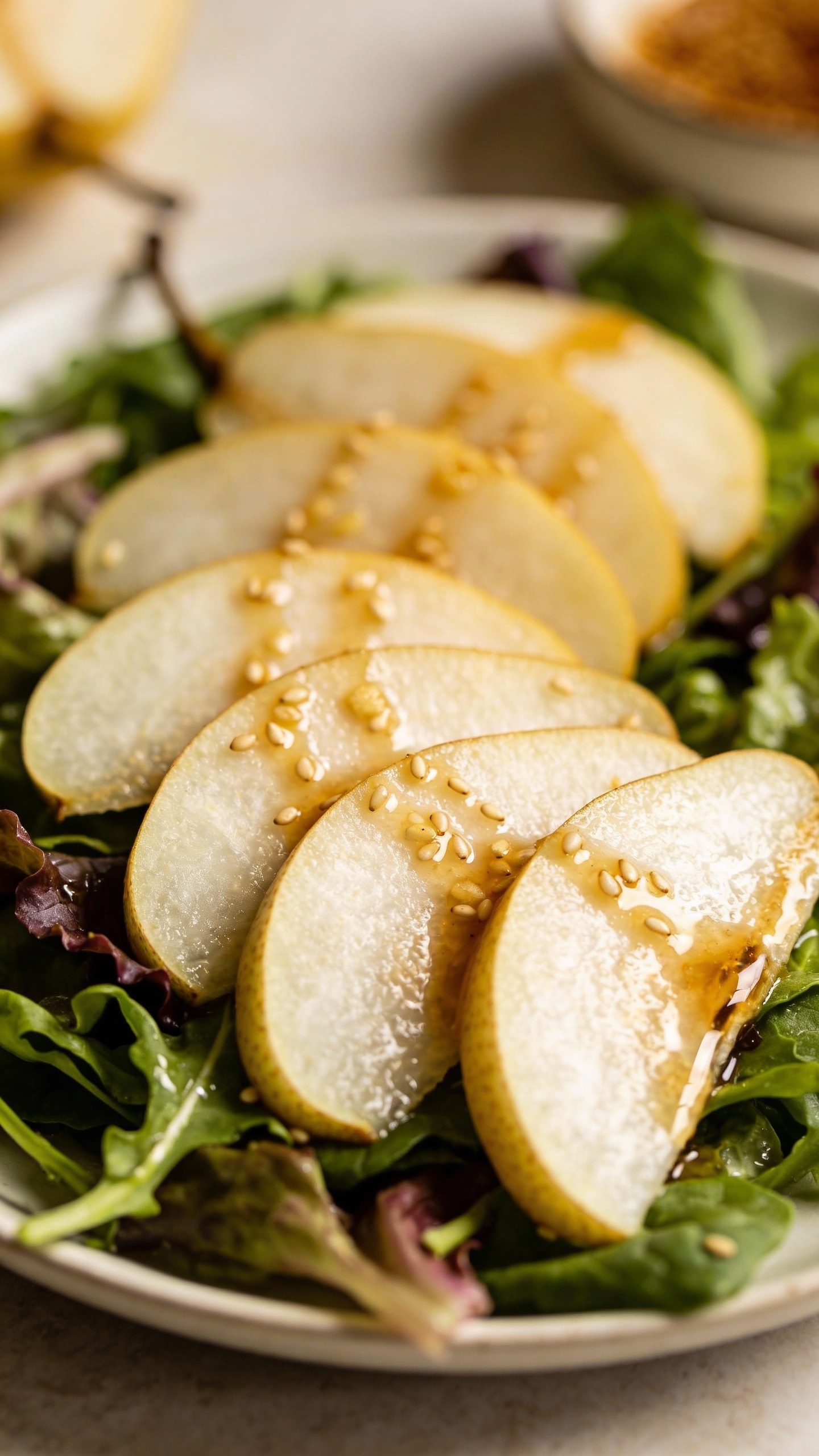 Sliced Asian pears on greens with ginger-sesame dressing